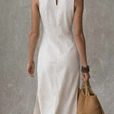 Vestido midi sin cuello con abertura en el dobladillo.